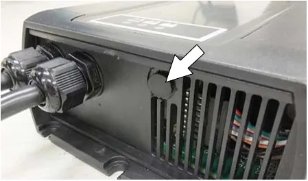 Photo of the black cap on the bottom side of the charger with an arrow pointing to it