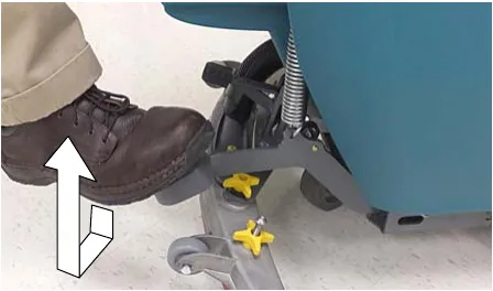 Photo of a foot stepping on the scrub head lift pedal to lower the scrub head