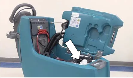 Photo of the recovery tank lifted with an arrow pointing to the water conditioning cartridge