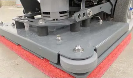 Photo of the orbital scrub head showing the isolators between the deck plate and driver plate