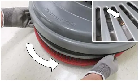 Photo of the single disk pad driver being turned counter-clockwise into the motor hub, with an inset of the scrub head window