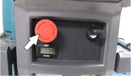 Photo of the red emergency shut-off button on the control console with an arrow pointing to it