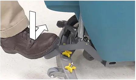 Photo of a foot stepping down on the scrub head lift pedal