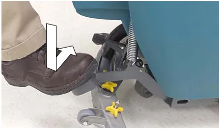 Photo of a foot stepping down on the scrub head lift pedal