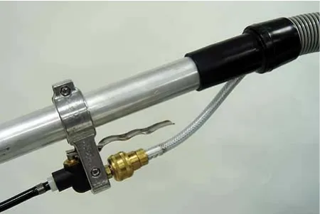 Off-aisle wand with the solution and vacuum hoses attached