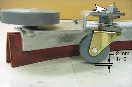 Adjusting the squeegee caster height so the blade clears the floor by 1/16 in (2 mm)