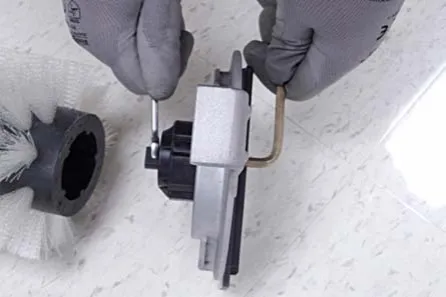 Holding the brush plug shaft with a wrench while loosening the hex screw