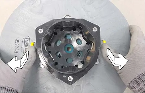 Pressing the yellow spring clips down and outward on the motor hub to open them