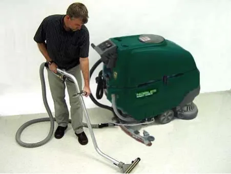 Operator using the off-aisle wand beside the machine