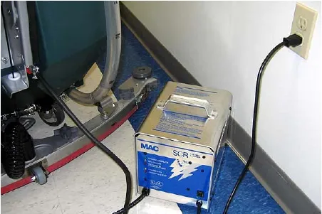 Off-board battery charger plugged into a wall outlet beside the machine