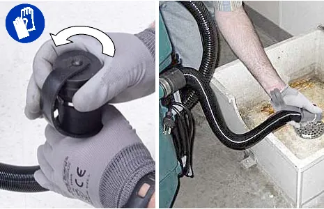 Removing the cap from the recovery tank drain hose and lowering the hose into a drain