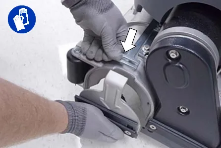 Pressing the spring tab to remove the idler plate from the brush