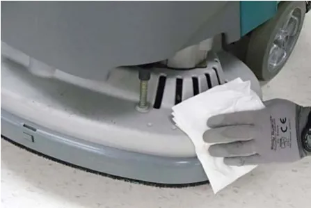 Wiping the scrub head with a damp cloth