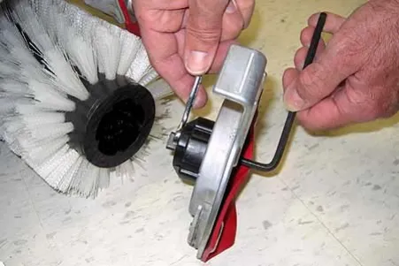 Wrench holding the brush plug shaft while a hex key loosens the 6 mm hex screw