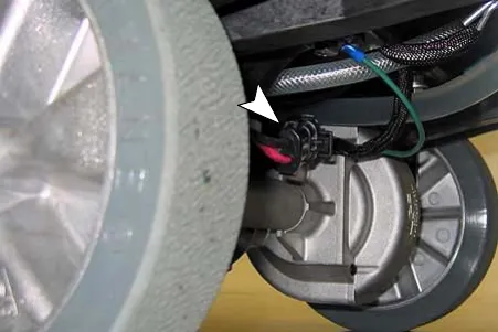 Drive motor wire connector (arrow) near the drive wheel