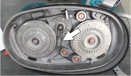 Dual disk brush drive belt inside the scrub head with an arrow pointing at the belt