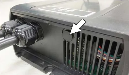 Underside of the charger with an arrow to the black cap over the profile dial
