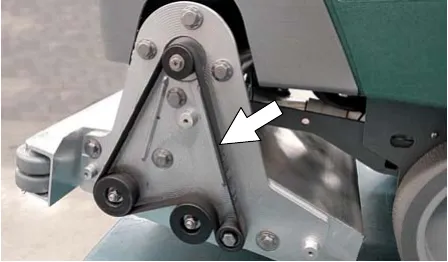 Cylindrical brush drive belt with an arrow pointing at the belt