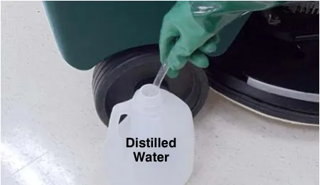 Other end of the hand pump hose submerged in a bottle of distilled water