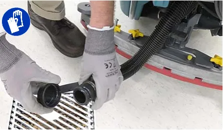 Recovery tank drain hose cap removed over a floor drain