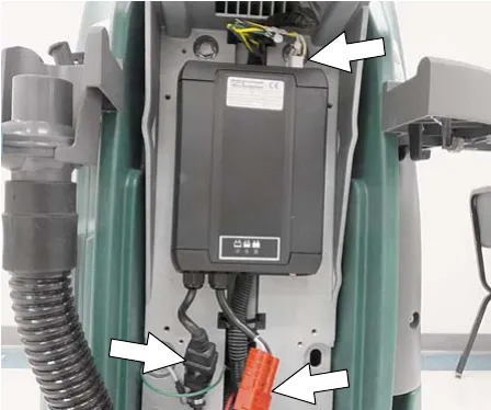 Battery charger mounted in the machine with arrows to the cable connections and the mounting screws