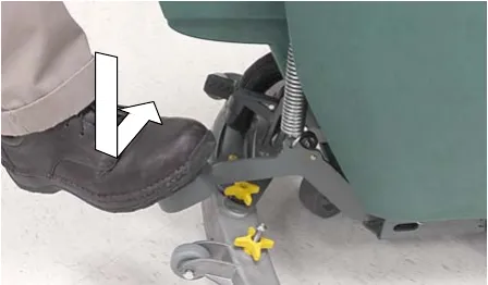 Foot stepping down on the scrub head lift pedal, arrows showing the motion