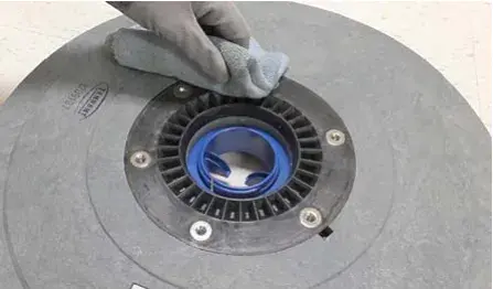 Cloth wiping debris from the hub connection area of an Insta-Click pad driver