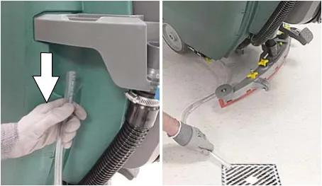 Solution hose being pulled down from the accessory rail and drained over a floor drain
