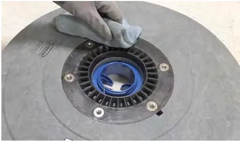 Wiping debris from the hub connection area of a Click-Quick pad driver with a cloth
