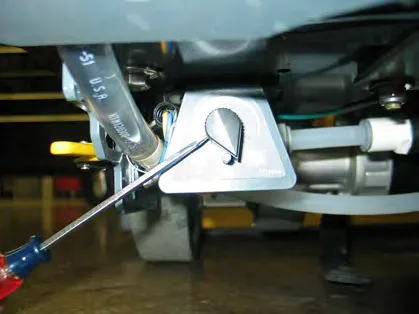 Tightening a set screw on the adjustment knob, which sits against the stop pin
