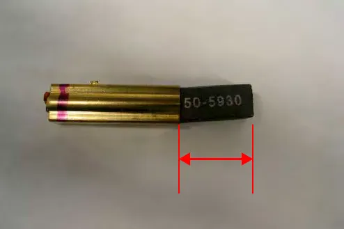 A carbon brush with a red arrow marking the carbon length to measure