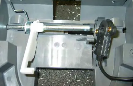Bail switch mechanism with its spring and white lever on the shaft inside the console