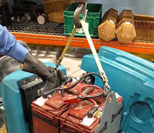Lifting a battery out of the battery compartment with a strap and hoist