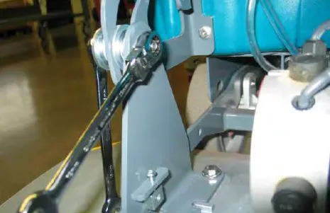 Wrench on the slotted top bolt of the scrub head bracket
