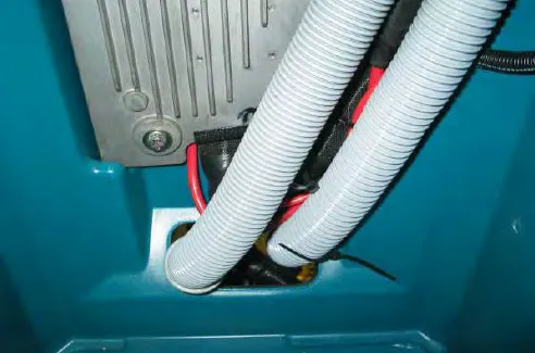 Hoses and wire harnesses secured by zip ties above the machine control module