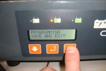Charger display reading PROGRAMMING SAVE AND EXIT with a finger on the up arrow button