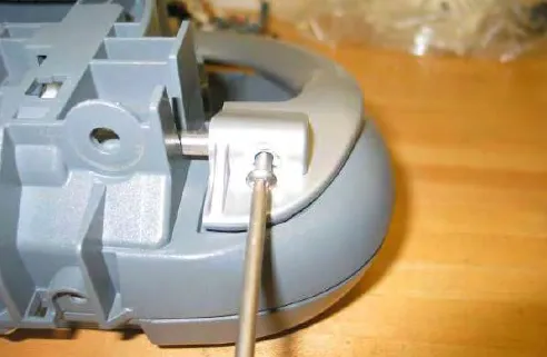 Removing a bail screw from the operator console with a screwdriver