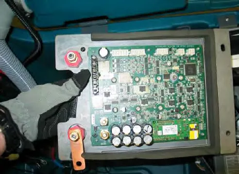 Heat sink and machine control module assembly, held by a gloved hand