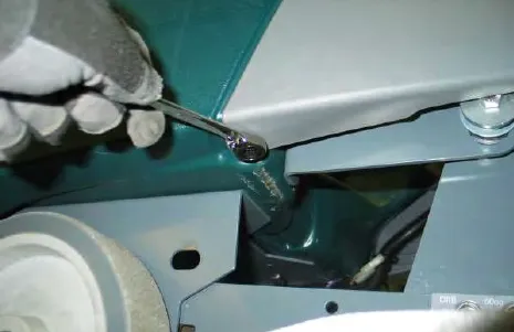 Removing a front shroud mounting bolt with a wrench