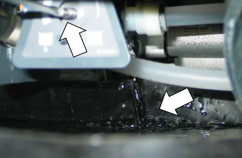Water running from the solenoid into the catch basin, with arrows at the valve stem and the water