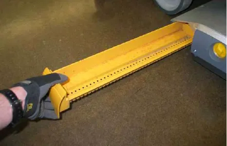 Lifting the yellow debris tray off the cylindrical scrub head