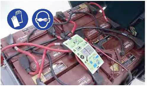 Battery compartment with the battery watering system hoses; gloves and goggles required