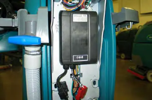 Onboard battery charger mounted at the rear of the machine with its electrical connections
