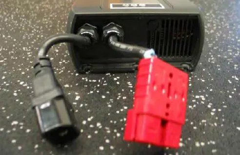 Battery charger removed, with its AC plug and red battery connector
