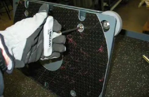 Removing a flat head screw from the lower plate with a screwdriver