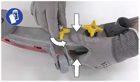 Loosening the two outside knobs on the squeegee assembly while squeezing the blade retainer and squeegee frame together; gloves required