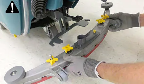 Lifting the rear squeegee assembly off the machine