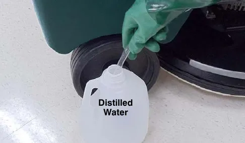 Hose end placed in a bottle labeled Distilled Water