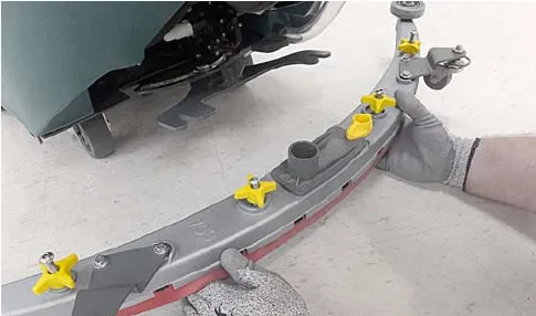 Squeegee assembly being mounted on the bracket and secured with yellow knobs