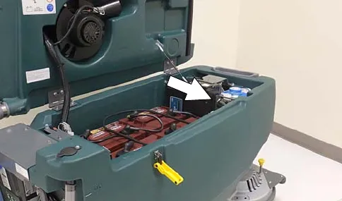 Recovery tank lifted with an arrow pointing at the cartridge in the battery compartment